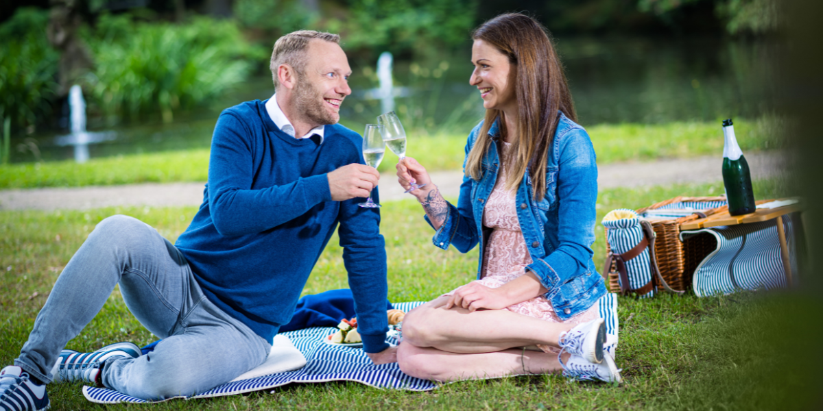Paerchen beim Anstoßsen im Schlosspark